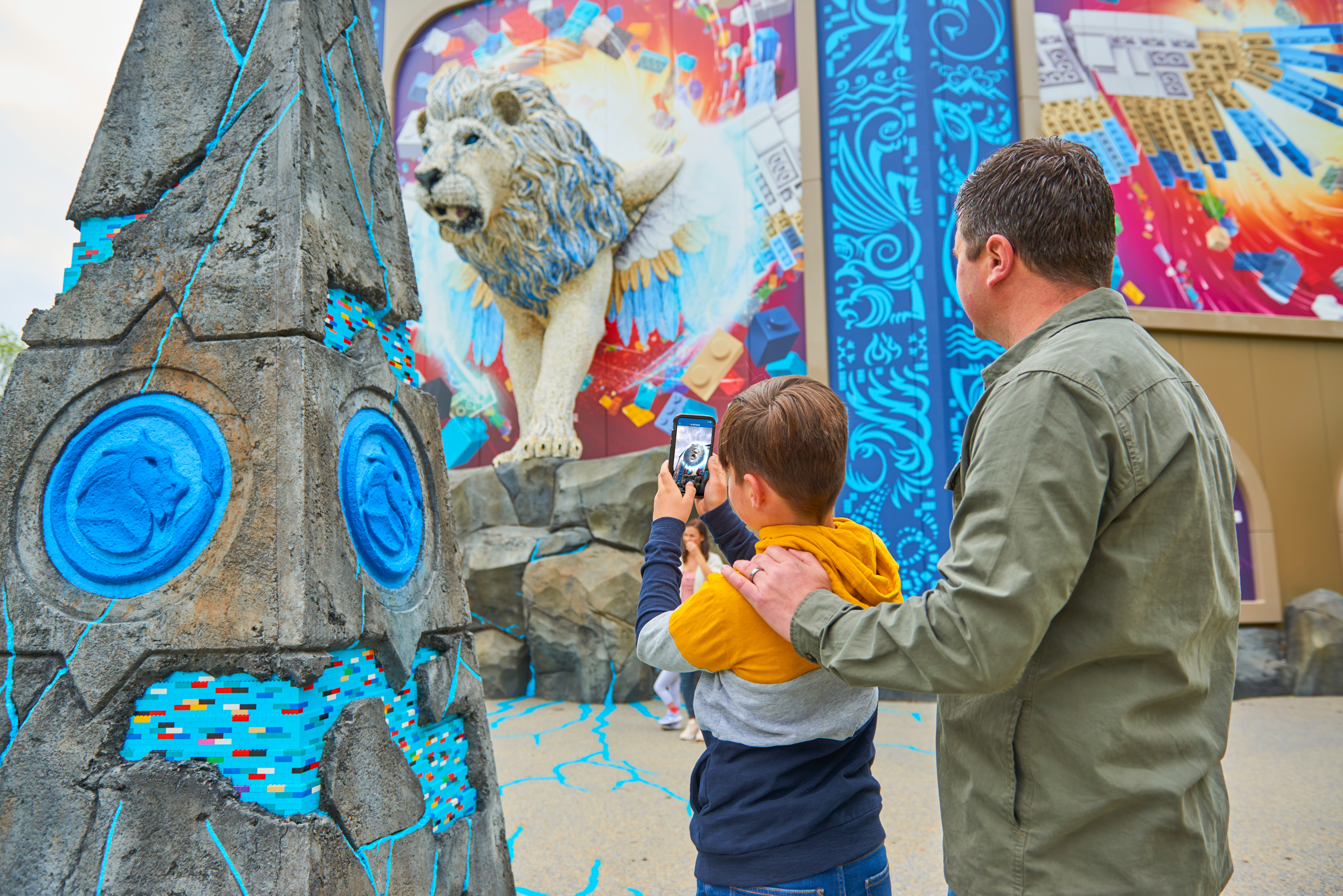 Father and son using Augmented Reality feature on Maximus the Sky Lion in LEGO MYTHICA