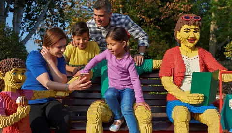 Family sat on bench using LEGOLAND Windsor app