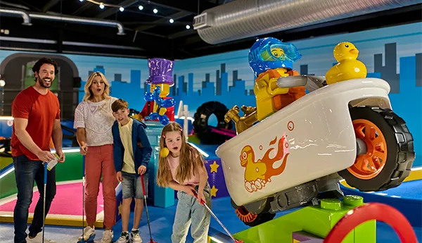Family playing LEGO City Adventure course at LEGOLAND Adventure Golf in Windsor, the world's first indoor LEGO golf experience