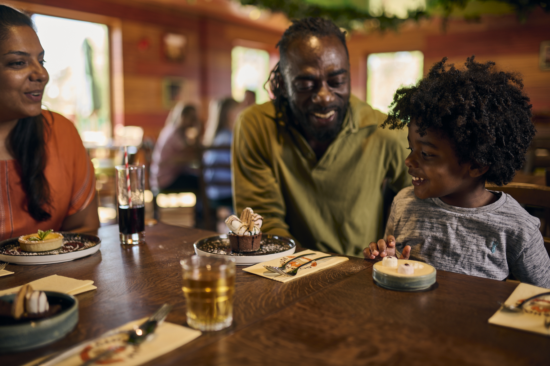 Family Eating At Clubhouse Restaurant At Woodland Village