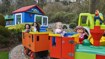3 girls smiling and waving on DUPLO Train