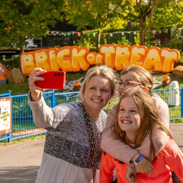 Family In Front Of Brick Or Treat Sign