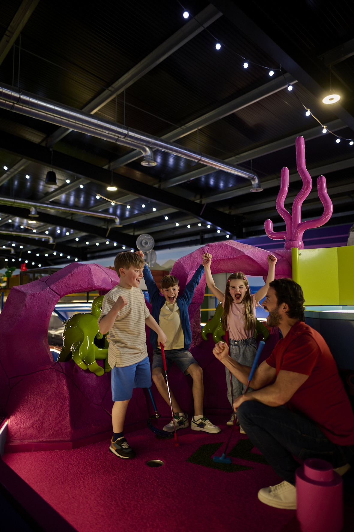 Family playing the Space course at LEGOLAND Adventure Golf - Indoor Mini Golf in Windsor