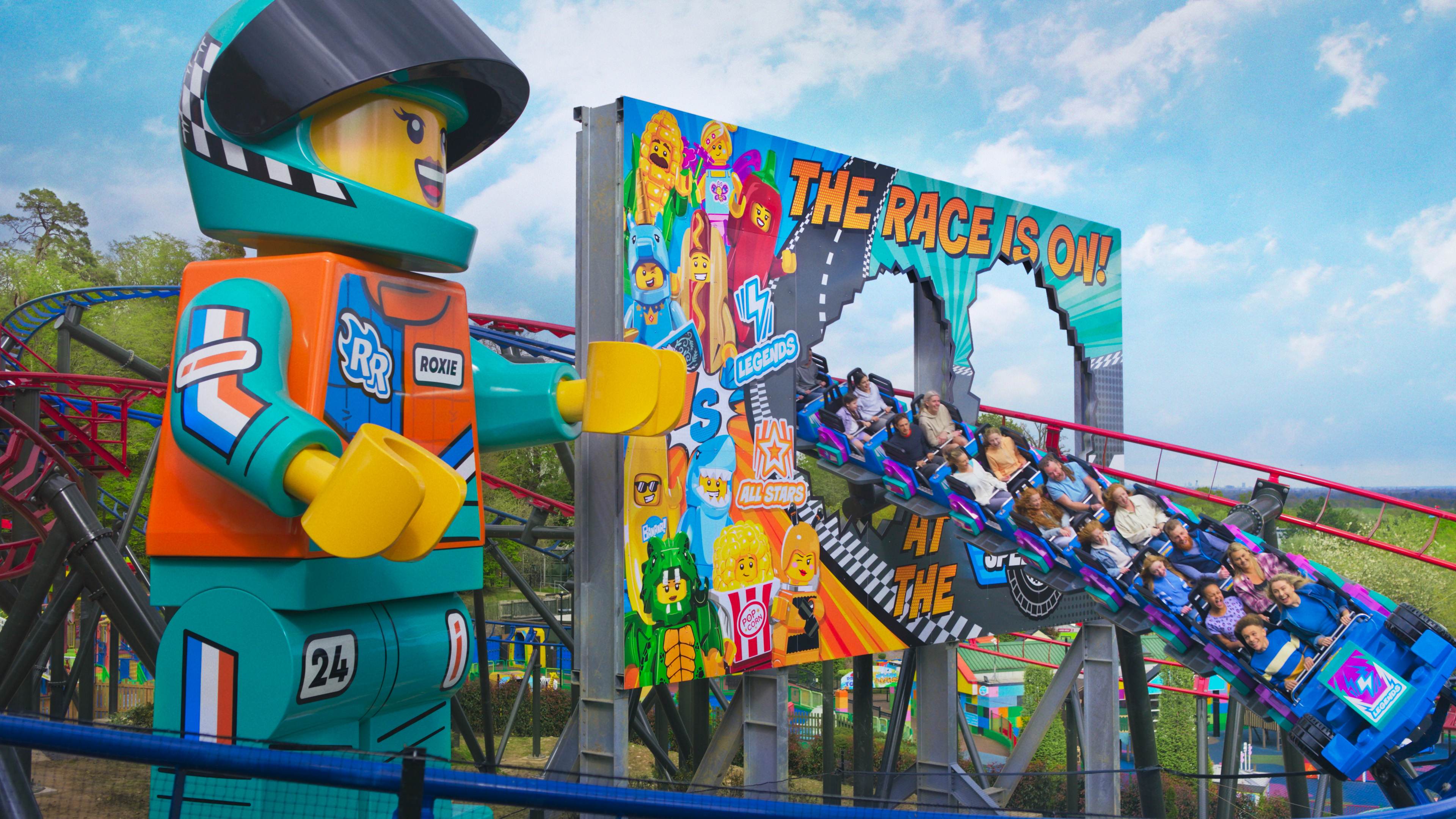 Families enjoying the rollercoaster Minifigure Speedway at the LEGOLAND Windsor Resort next to the giant Minifigure Roxie Racer