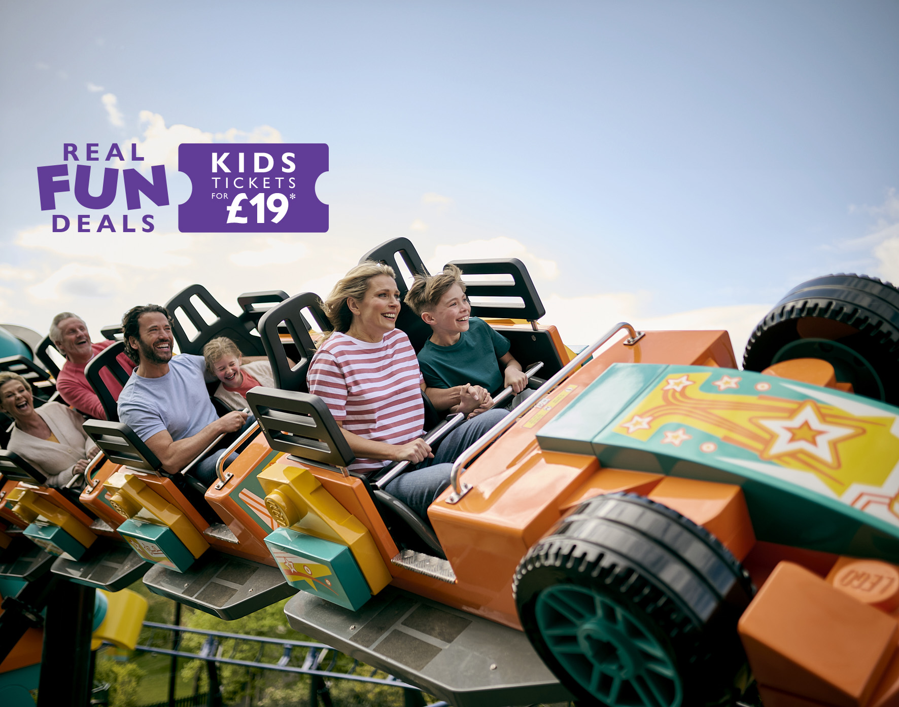 Family including parents, children and grandparents enjoying Minifigure Speedway at the LEGOLAND Windsor Resort. Real Fun Deals in summer 2024 with kids tickets from just £19 (Ts&Cs apply)