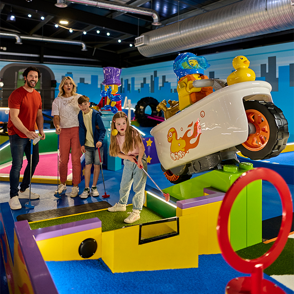 Family playing LEGO City course at LEGOLAND Adventure Golf in Windsor, the world's first indoor LEGO golf experience